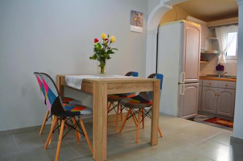 uma cozinha com uma mesa com cadeiras e um vaso de flores em Spiros full House in Marathias em Marathias