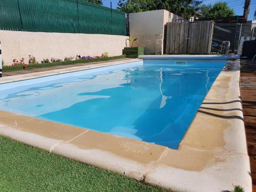 a swimming pool with blue water in a yard at La Grange des Griottiers in Saint-Priest