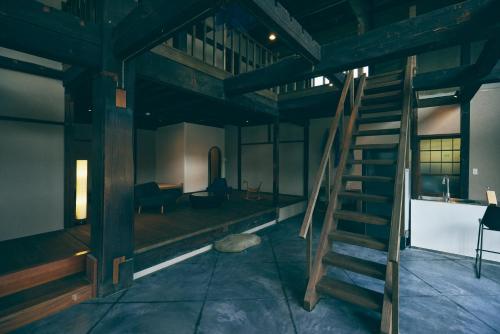 a room with a wooden staircase in a building at Kominkayado LOOF Shikinoie in Ōtsuki