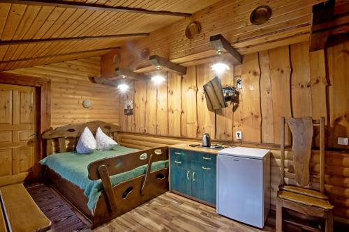 a bedroom with a bed in a wooden cabin at Садиба "333" in Yaremche