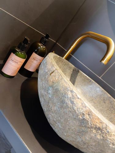 three bottles of wine sitting next to a sink at Snurk Texel in Den Burg