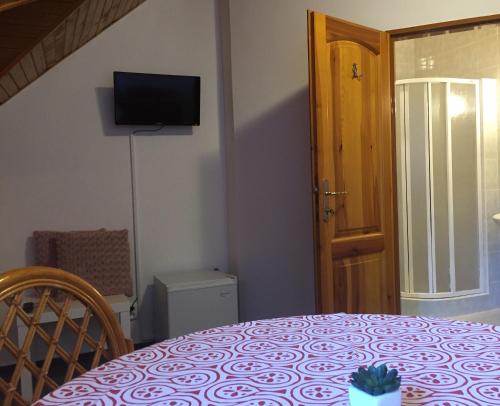 a room with a table and a television on the wall at Penzion Na Vyhlídce in Frýdlant nad Ostravicí