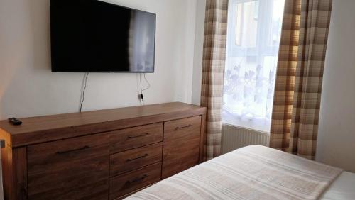 a bedroom with a dresser with a flat screen tv on the wall at The Old Surgery in Blaenau-Ffestiniog