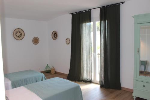 une chambre avec deux lits et une fenêtre dans l'établissement Le Terracotta , 2chambres, Terrasse, Piscine, Parking gratuit, Wifi, Climatisation, à Marseillan
