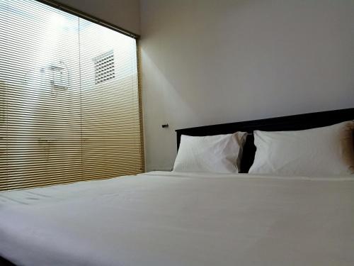 a bedroom with a white bed with a large window at Greenfield Bedz in Hatton