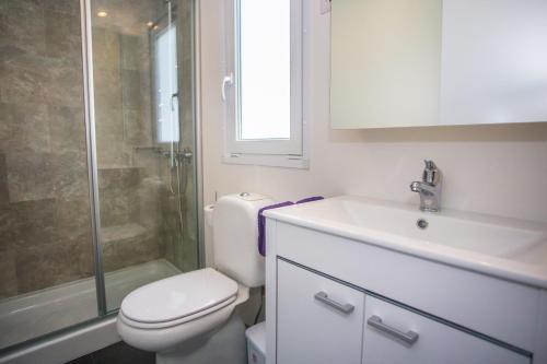a bathroom with a toilet and a sink and a shower at CHERRY Premium JADE Mobile homes Zelena Laguna in Poreč
