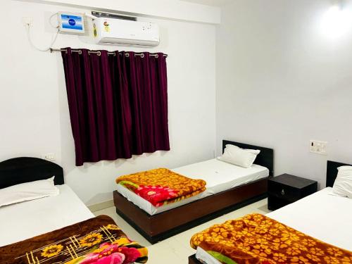 a room with two beds and a red curtain at Gaurav guest house in Bodh Gaya
