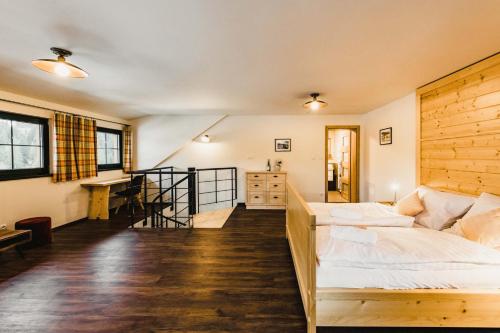 a bedroom with a bed and a desk in it at Apartmány Na Soutoku - Březník in Modrava