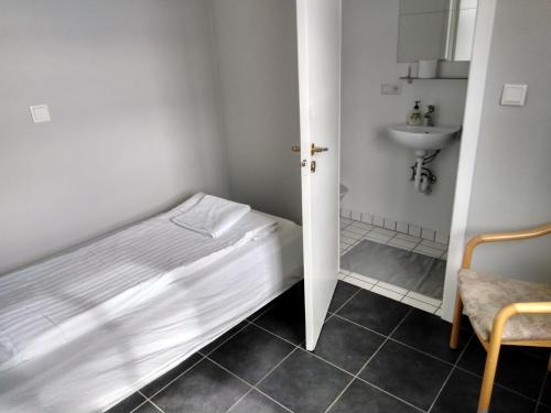 a small bedroom with a bed and a sink at Guesthouse Skógafoss in Skogar