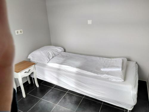 a white bed in a room with a white wall at Guesthouse Skógafoss in Skogar