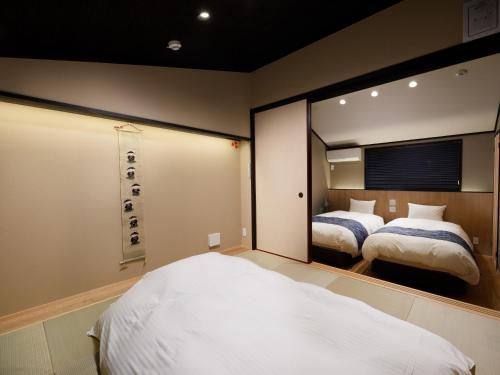 a bedroom with two beds and a large mirror at Kanade Fushimiinari-Inometei in Kyoto