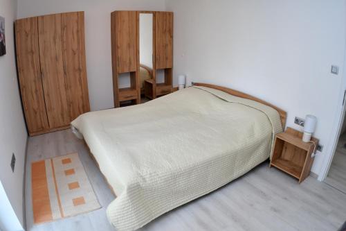 1 dormitorio con 1 cama grande y armarios de madera en Fűzliget Ezüstnyár, en Balatonfűzfő