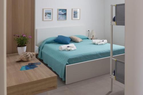 a bedroom with a bed with towels on it at Marezè in Punta Secca