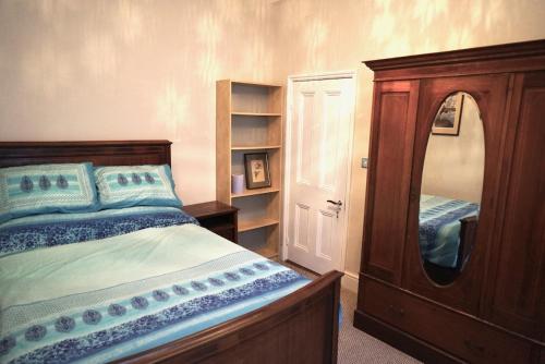 a bedroom with a bed with a dresser and a mirror at Tottenham Stadium double room in London