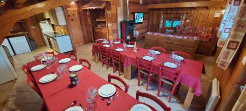 - une vue sur la salle à manger dotée de tables et de chaises rouges dans l'établissement Chalets Julien, à Le Thillot