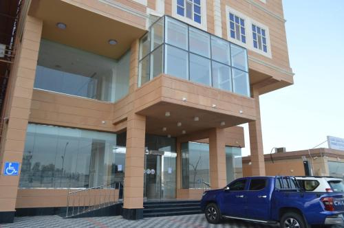 a blue suv parked in front of a building at فندق كارم in Raḩīmah