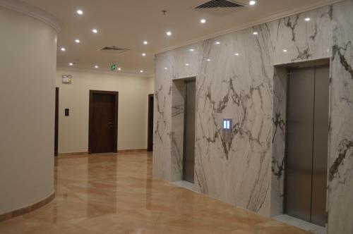 a lobby with a marble wall in a building at فندق كارم in Raḩīmah