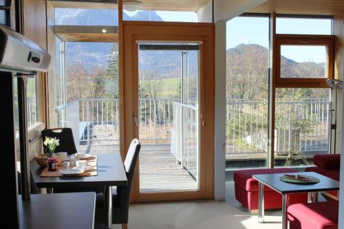 ein Wohnzimmer mit einem Tisch und einer großen Glastür in der Unterkunft Oase Berta in Bad Aussee