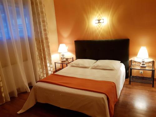 ein Schlafzimmer mit einem großen Bett mit zwei Lampen und einem Fenster in der Unterkunft WEEK END EVASION A BANYULS SUR MER DANS PYRENEES ORIENTALES in Banyuls-sur-Mer