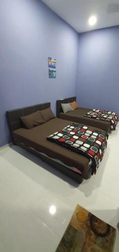 two beds are sitting in a room at OYO 90252 Penginapan Wahee in Kuala Terengganu