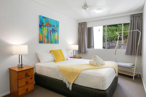 a bedroom with a large bed and a window at Azure Sea Whitsunday Resort in Airlie Beach