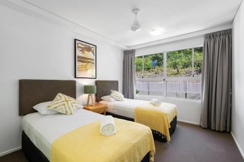 a hotel room with two beds and a window at Azure Sea Whitsunday Resort in Airlie Beach