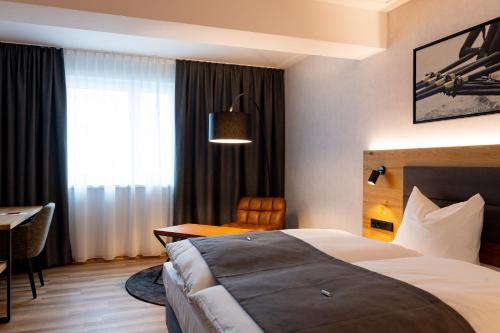 a hotel room with a bed and a desk at mk hotel passau in Passau