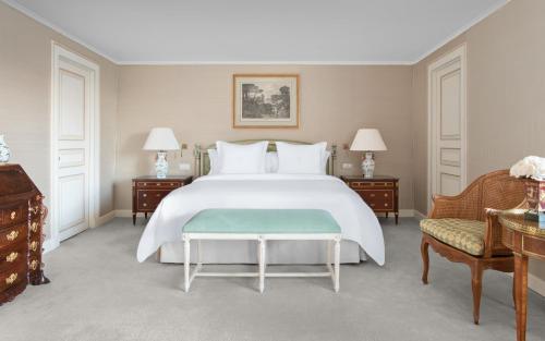 a bedroom with a large white bed and two chairs at Four Seasons Hotel Ritz Lisbon in Lisbon