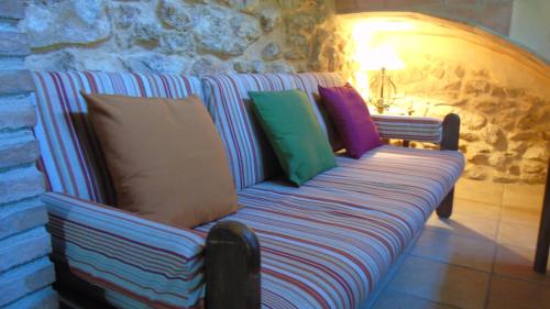 ラメトリャ・デ・マールにあるMas de la Forasteraのカラフルな枕付きのソファが備わる客室です。