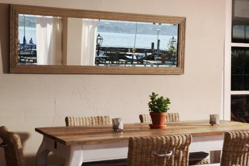 a dining room with a table and a mirror at Hotel Hirschen am See in Meilen