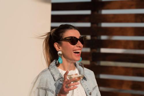 a woman wearing sunglasses holding a glass of wine at Marezè in Punta Secca