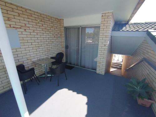 a room with a table and chairs and a brick wall at Aspley Sunset Motel in Brisbane