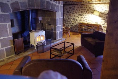 - un salon avec une cheminée dans un bâtiment en pierre dans l'établissement Le Grand Gîte, à Sainte-Eulalie