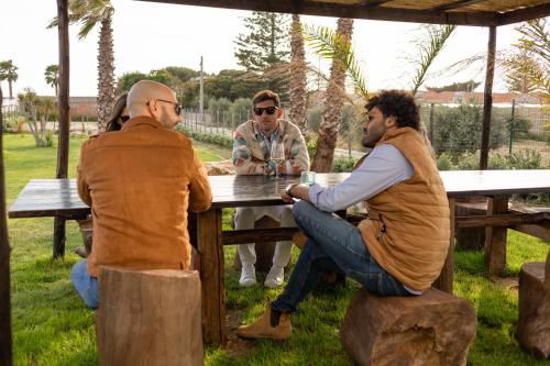 a group of men sitting at a picnic table at Marezè in Punta Secca