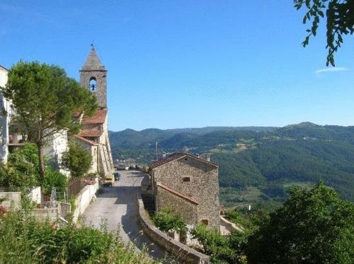 a building with a clock tower on a hill at Borgo San Pietro in Agnone