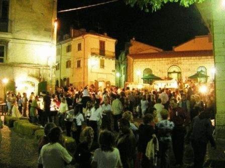 a large crowd of people standing in a street at night at Borgo San Pietro in Agnone