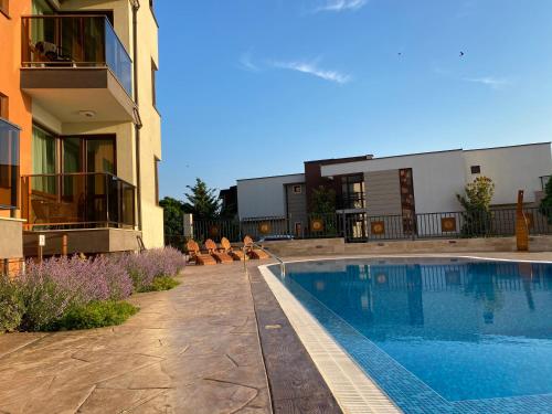 a swimming pool in front of a building with a house at St. Panteleimon Beach Hotel in Nesebar