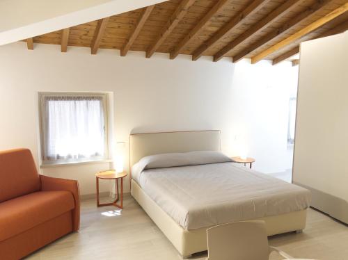 a bedroom with a bed and a couch at Appartamenti Ca' Gabri & Cici in Garda