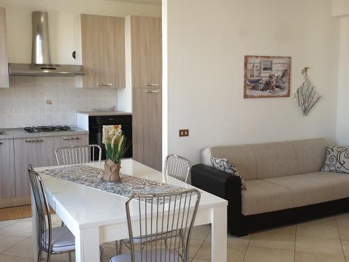 cocina y sala de estar con mesa y sofá en Casa Mattarella en San Vito lo Capo
