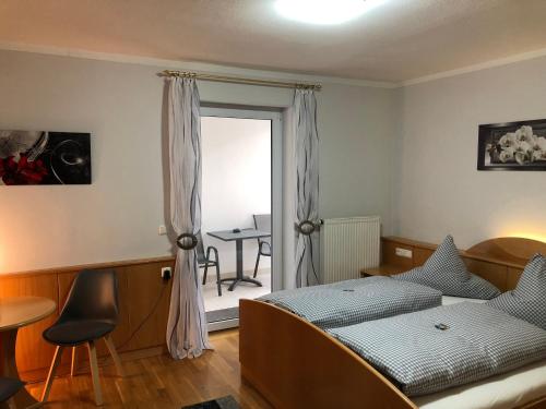 1 dormitorio con cama, mesa y ventana en Hotel u. Restaurant Goldener Greifen en Donauwörth