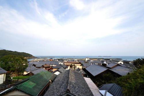 a group of houses with the ocean in the background at 日向美々津の宿_Hyuga Mimitsu INN in Hyuga