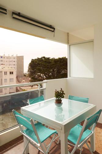 une table blanche et des chaises dans une pièce avec une fenêtre dans l'établissement Emplacement idéal 200m de la plage, à Saint-Jean-de-Monts