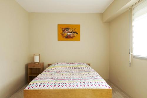 une chambre avec un lit et un tableau au mur dans l'établissement Emplacement idéal 200m de la plage, à Saint-Jean-de-Monts