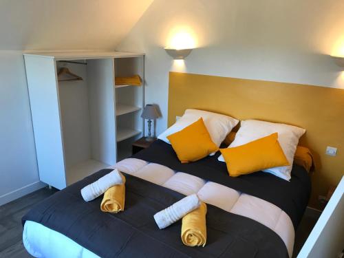een slaapkamer met een groot bed met gele en witte kussens bij TREAS GLAZ in Plouescat