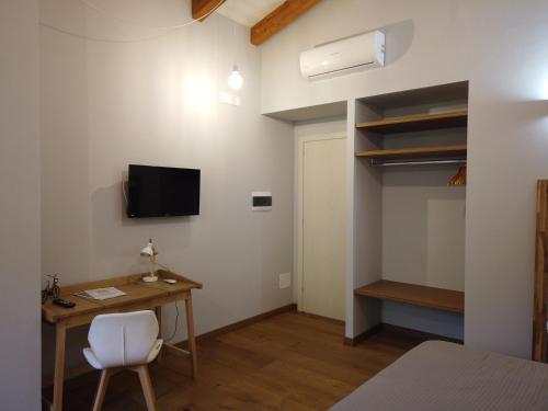 a bedroom with a desk and a bed and a tv at Il Mandorlo in Amantea