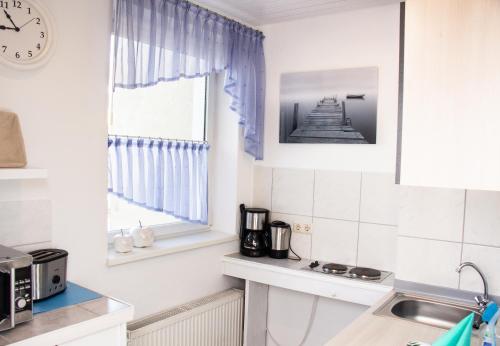 a kitchen with a sink and a clock on the wall at Ferienwohnung am Alten Hafen in Wismar
