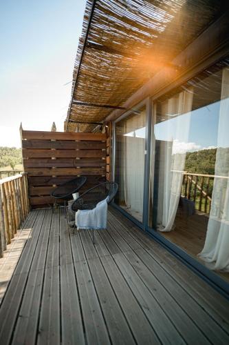 a wooden deck with a table and chairs on it at Monte Gois Country House e Spa in Curvatos