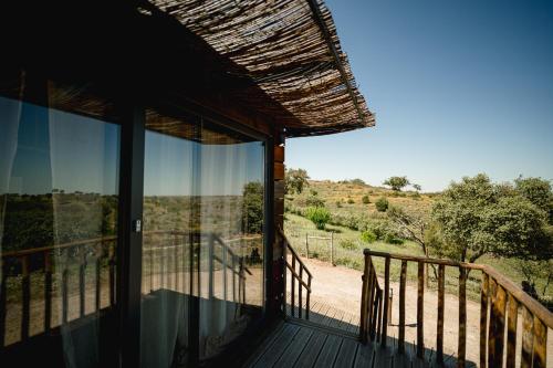a view from the deck of a house with glass doors at Monte Gois Country House e Spa in Curvatos