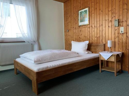 a bedroom with a bed and a table with a lamp at Hotel Garni Siedlerstube in Nürtingen