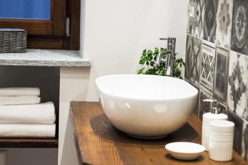 a bathroom with a white bowl sink on a wooden counter at Locanda Vecchio Cipresso in Chiaverano